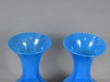 two blue vases sitting next to each other on a table