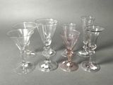 six wine glasses sitting next to each other on a table