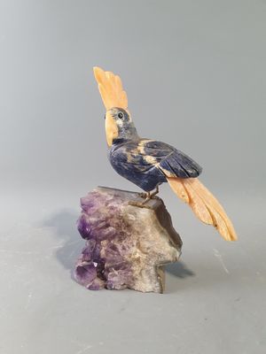 une figurine représentant un oiseau perché sur un rocher