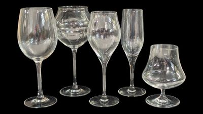 cinq verres à vin vides et un verre à vin à moitié vide