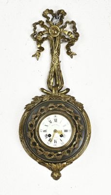 a clock hanging on the wall with a cross on it