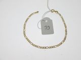 Gros plan sur un bracelet en chaîne en or portant une étiquette