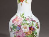 un vase orné de fleurs peintes, posé sur une table