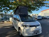 a white van parked in a parking lot with a tent on top