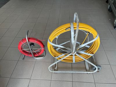 a yellow and red hose on a cart next to a red and yellow hose