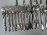a lot of silver spoons and forks on the table