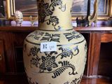 a large vase sitting on a table in front of a painting