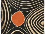 a black and orange rug with an orange dot on it