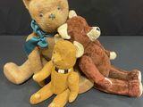 three teddy bears sitting next to each other on a table