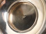 a close up view of a silver vase with a hole in it