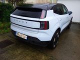 the rear end of a white suv parked in front of a garage