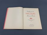 un livre ouvert posé sur une table, sur fond bleu
