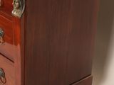 a small wooden chest of drawers with a marble top