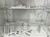 a glass display case with many different jewelry items on it