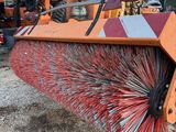 a close up of a broom on the ground in front of a truck