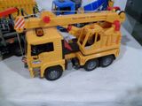 un camion-jouet jaune surmonté d'une grue