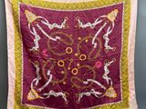 a close up of a red and yellow scarf hanging on a clothes line