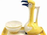 a yellow tray with a white bowl and a yellow bird on it