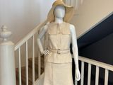 un mannequin portant une robe et un chapeau, sur les escaliers