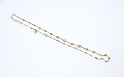 a close up of a gold chain bracelet on a white surface