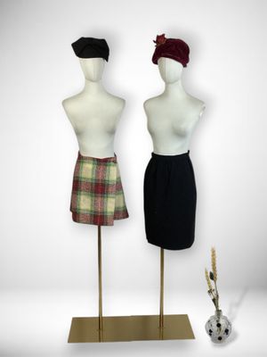 two mannequins are standing next to each other on a stand