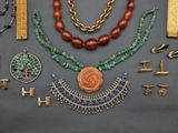 many different necklaces and bracelets laid out on a table