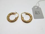 a pair of gold hoop earrings with a price tag