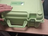 a person holding a green plastic case on a table