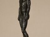 bronze statue of a man standing on a glass table