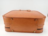 tan leather suitcase sitting on a white surface next to a black suitcase