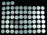 a lot of silver coins on a black surface