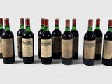 six bottles of wine are lined up on a white surface
