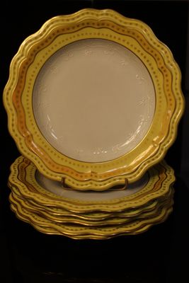 yellow and white plates stacked on top of each other on a table
