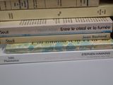 many books stacked on top of each other on a table