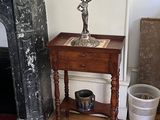 une petite table sur laquelle se trouve un vase, dans un coin de la pièce