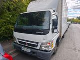 un camion blanc garé sur le bord de la route