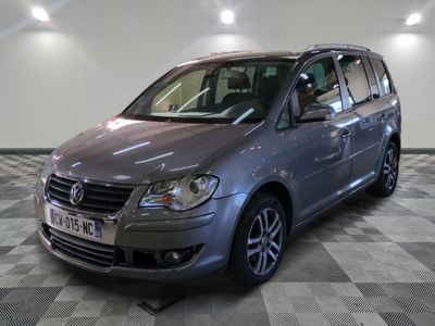 La camionnette argentée est garée dans le garage, sur un sol à damier.