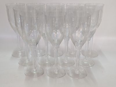 six clear wine glasses lined up in a row on a white surface