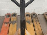 un cariste assis sur une palette dans un parking