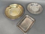 three silver trays and a silver plate on a table