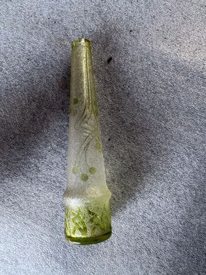 une bouteille en verre verte ornée d'un motif vert