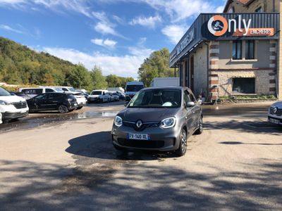 une voiture garée devant un immeuble sur lequel est accrochée une pancarte
