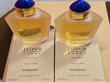 deux flacons de parfum posés sur une boîte, elle-même posée sur une table