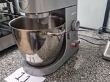 a silver mixer on a granite counter top next to a blender
