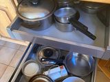 pots and pans in the bottom drawer of a kitchen cabinet