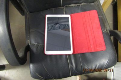 une photo d'un téléphone portable posé sur un fauteuil en cuir