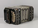 an old black accordion sitting on top of a white table