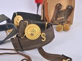 a brown belt with a gold buckle and a red pom pom on it