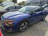a blue car parked in a parking lot next to other cars