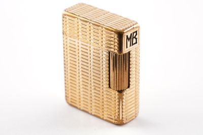 an image of a gold lighter sitting on top of a white surface